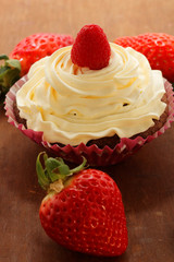 Homemade delicious chocolate cupcakes with fresh raspberry and cream on top. Delicious cupcake for Valentine’s Day. 
