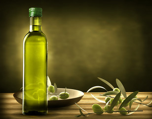 bottle of oil with olive branches on the wooden table
