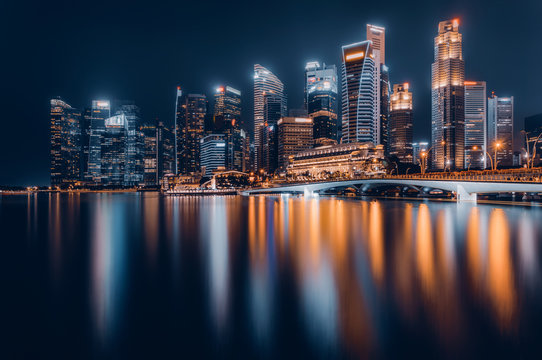 Fototapeta Singapore city skyline. Business district view. Downtown reflected in water at night in Marina Bay. Travel cityscape