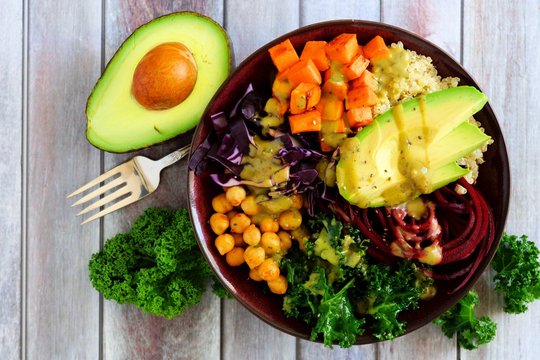 Healthy lunch bowl with quinoa, avocado, chickpeas, vegetables on a wood background, Healthy eating concept. Top view.