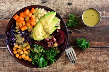 Buddha bowl with quinoa, avocado, chickpeas, vegetables on a wood background, Healthy food concept. Top view.