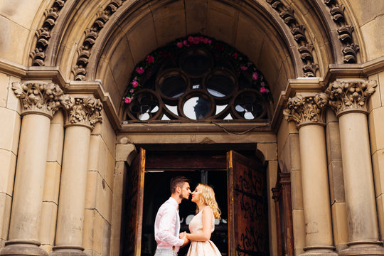 couple standing face to face and holding hands on the background of the arch and door