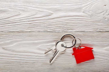 Real estate concept, key chain and keys on wooden background