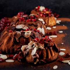 Delicious freshly baked pie with chocolate couverture and almond and pomegranate on slate plate kitchen table background