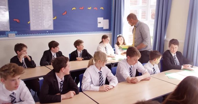 4k, Group of students receiving schoolwork from teacher.