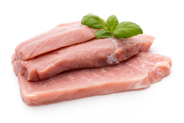 Fresh pork fillet with basil on a white background.