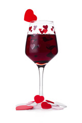 Glass of red wine with red and pink heart shape