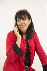 brunette woman talking on cell on white background with kind and happy attitude