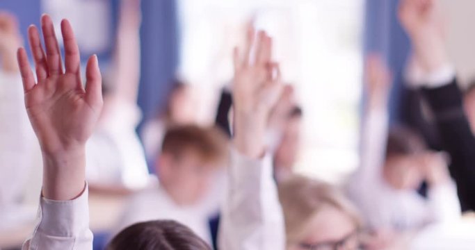 4k, Close-up shot of  school children in classroom raising arms.