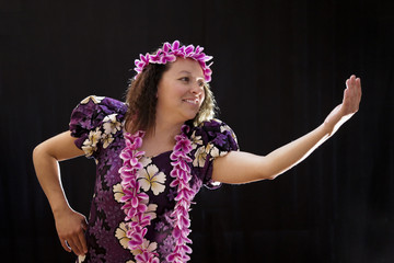 Fototapeta premium Smiling female Hawaiian girl dancing and singing with musical instruments like the ukulele