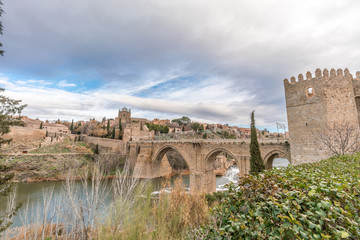 Obraz premium View of Toledo walls, Monastery of San Juan de los Reyes and Puente de San Martin Bridge over the (Tajo) Tagus River