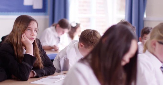 4k, School girl day dreaming beside her classmate in classroom