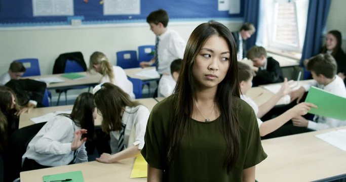 4k, Portrait of a frustrated young teacher in a classroom full of children.