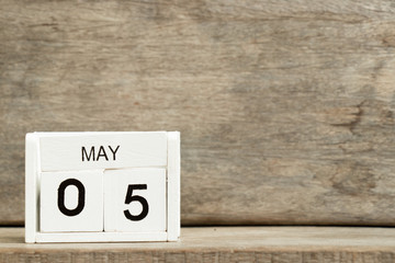 White block calendar present date 5 and month May on wood background