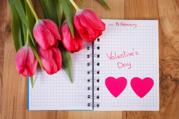 Valentines Day written in notebook, fresh tulips and hearts, decoration for Valentines Day