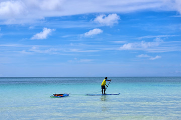 Man is enjoy a view in standup paddleboarding over the ocean
