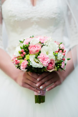 Obraz na płótnie Canvas Hands of the bride and the bridal bouquet.