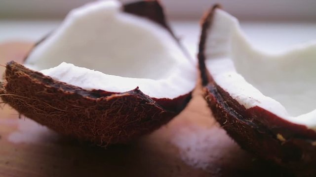 Fresh coconut with flowing coconut milk on a bamboo board.
