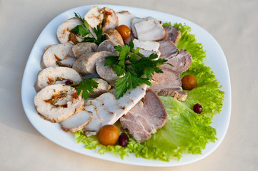 Assorted meat cut with chicken roll, homemade sausage, lard and ham on lettuce leaves