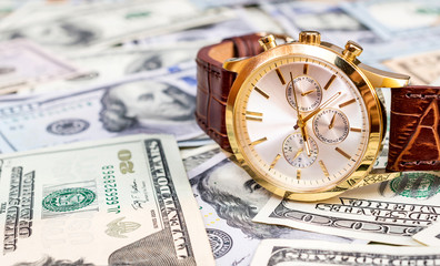Wrist watch on dollars background. Business concept.
