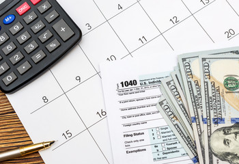 Tax forms with money, calculator and calendar on the table. Business concept.