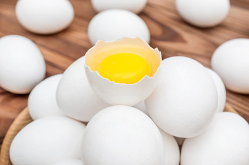 Broken egg on the heap of whole eggs. Close up.