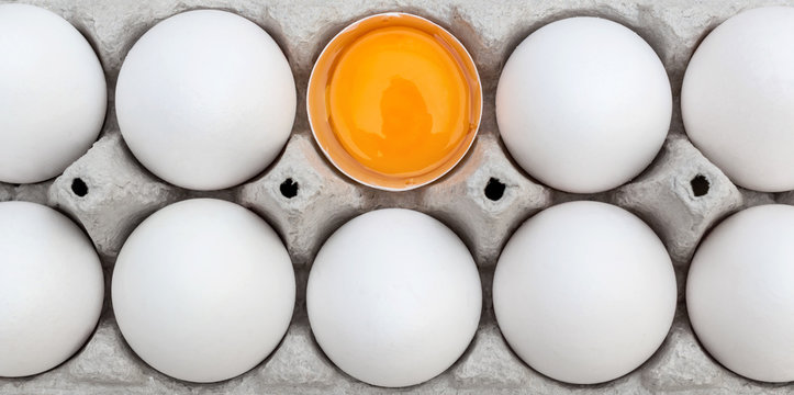 Broken Egg With Whole Eggs In Box. Top View.