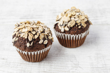 Chocolate muffin decorated with oatmeal flakes.