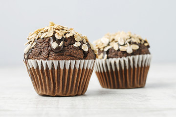Chocolate muffin decorated with oatmeal flakes.