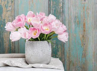 Bouquet of pink tulips, rustic wooden background.