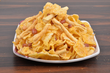 traditional indian corn flakes namkeen with peanuts in white plate