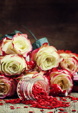 Red sweet heart, Valentines Day card on background of fresh pink and white roses, selective focus