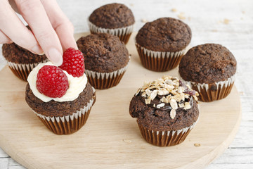 Woman prepares muffins decorated with fresh fruits. Healthy snack