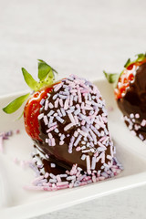 Chocolate dipped strawberries decorated with sprinkles.