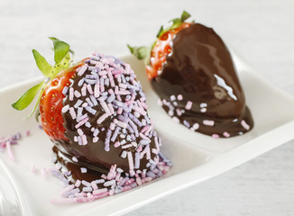 Chocolate dipped strawberries decorated with sprinkles.