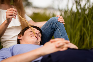 Smiling man lying over his woman's lap