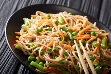 Buckwheat Soba with vegetables and sesame close-up on a plate. horizontal