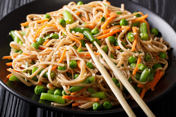 Japanese food: Soba with carrots, peas and green beans close-up. horizontal