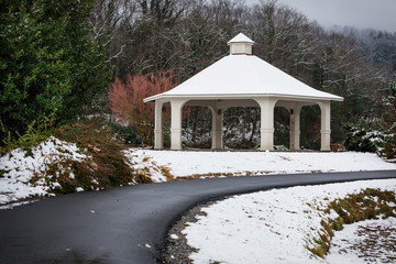 A little garden path leading around a snow covered gazebo