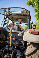 Ackerbau, junger Landwirt blickt von seinem Traktor