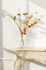 Clear Glass Vase with Wilted Flowers on a Fireplace