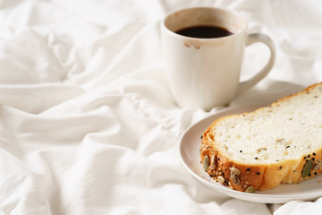 coffee cup and bread in bed, cozy breakfast