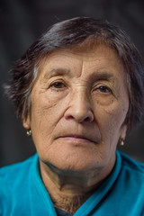 portrait of an elderly thoughtful woman on a dark background