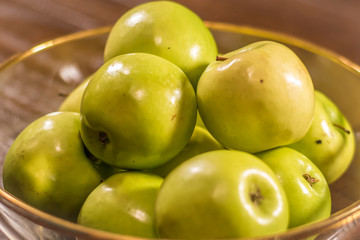 green apples in bowl on wooden table