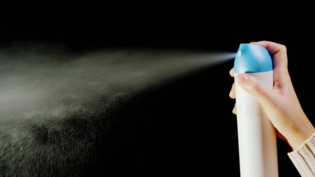 Hand with an aerosol can. Spray spray on a black background
