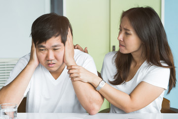 Asian couple in bad relationship concept. Bored husband closed his ears with hands do not want to listening voice of anger wife.