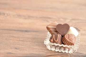 A variety of chocolates displayed in a fancy glass container