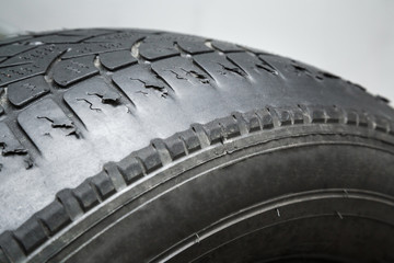 Old, damaged and worn black tire tread. Change time. Tire tread problems and solutions concept.