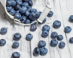 American blueberries scattered over white wooden background
