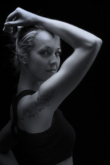 Beautiful fit and healthy blond woman portrait in black top with arm lift up artistic conversion